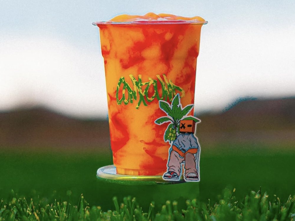 The Compound Coffee iced drink in the grass
