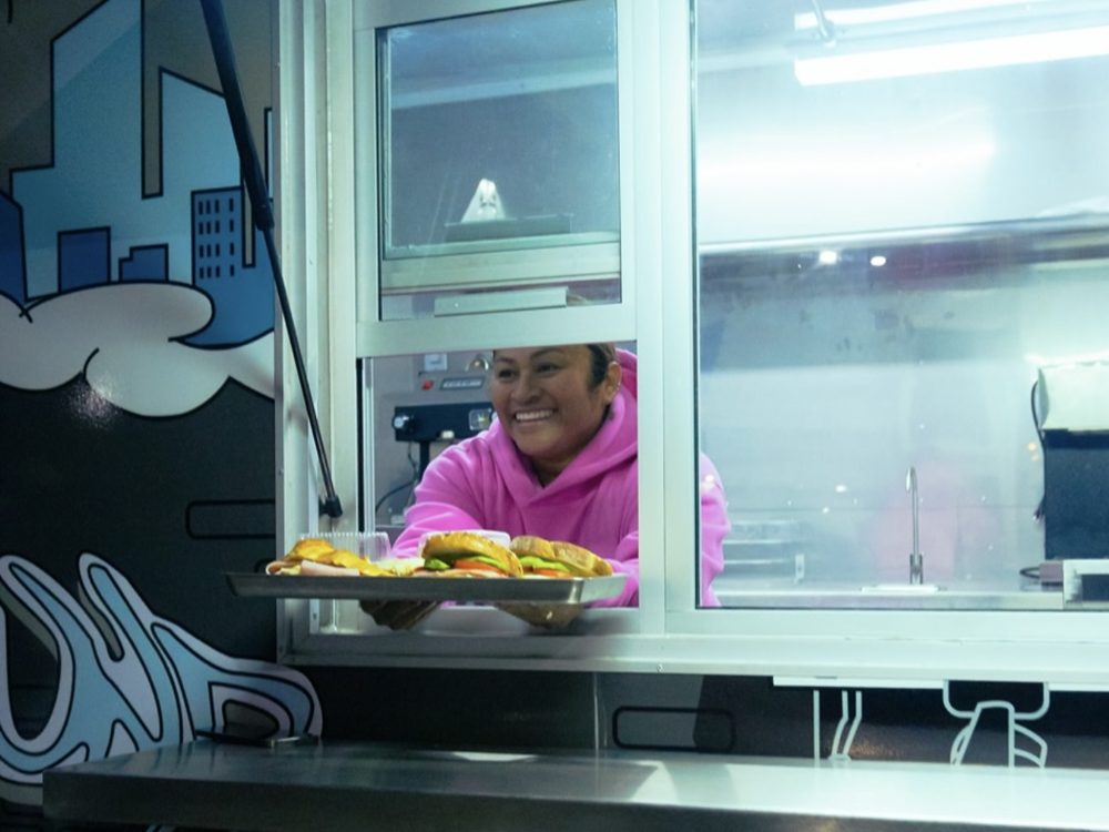 The Compound Coffee team member serving food through the truck window